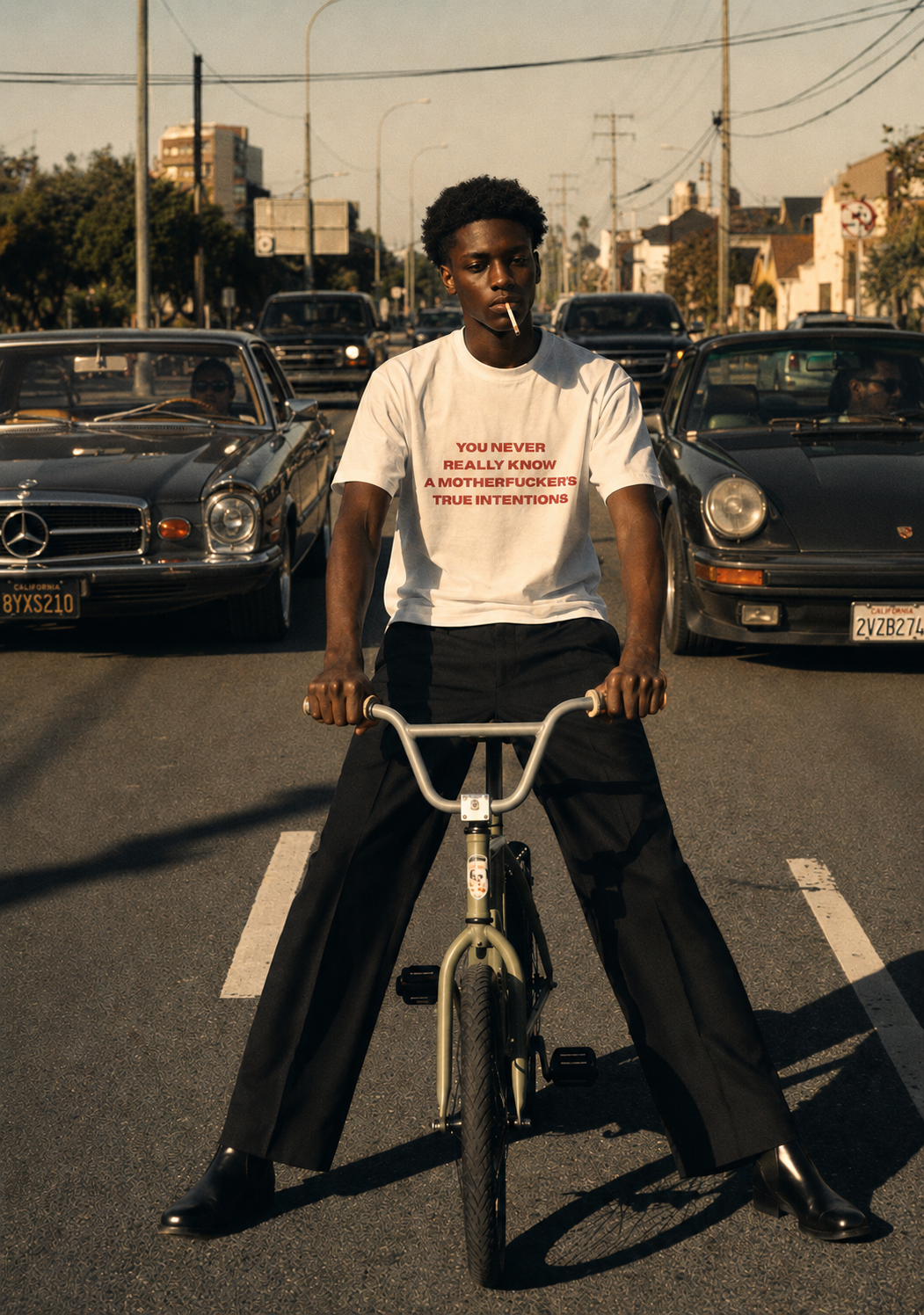 Model wearing BISHOP white tee on BMX bike in LA traffic - EUPHORIC collection campaign by Nostalgic Misfits