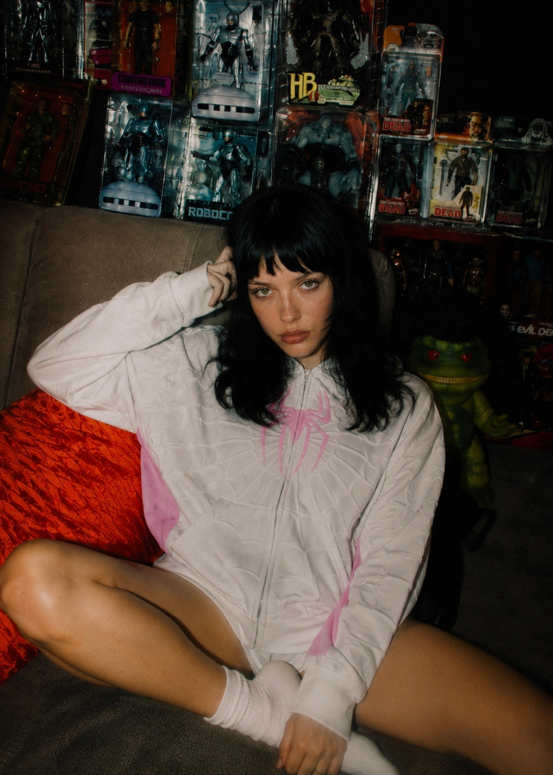 Nostalgic Misfits Ghost Zip white pink spidey hoodie female model sitting cross legged holding vintage walkman retro collector room white socks editorial