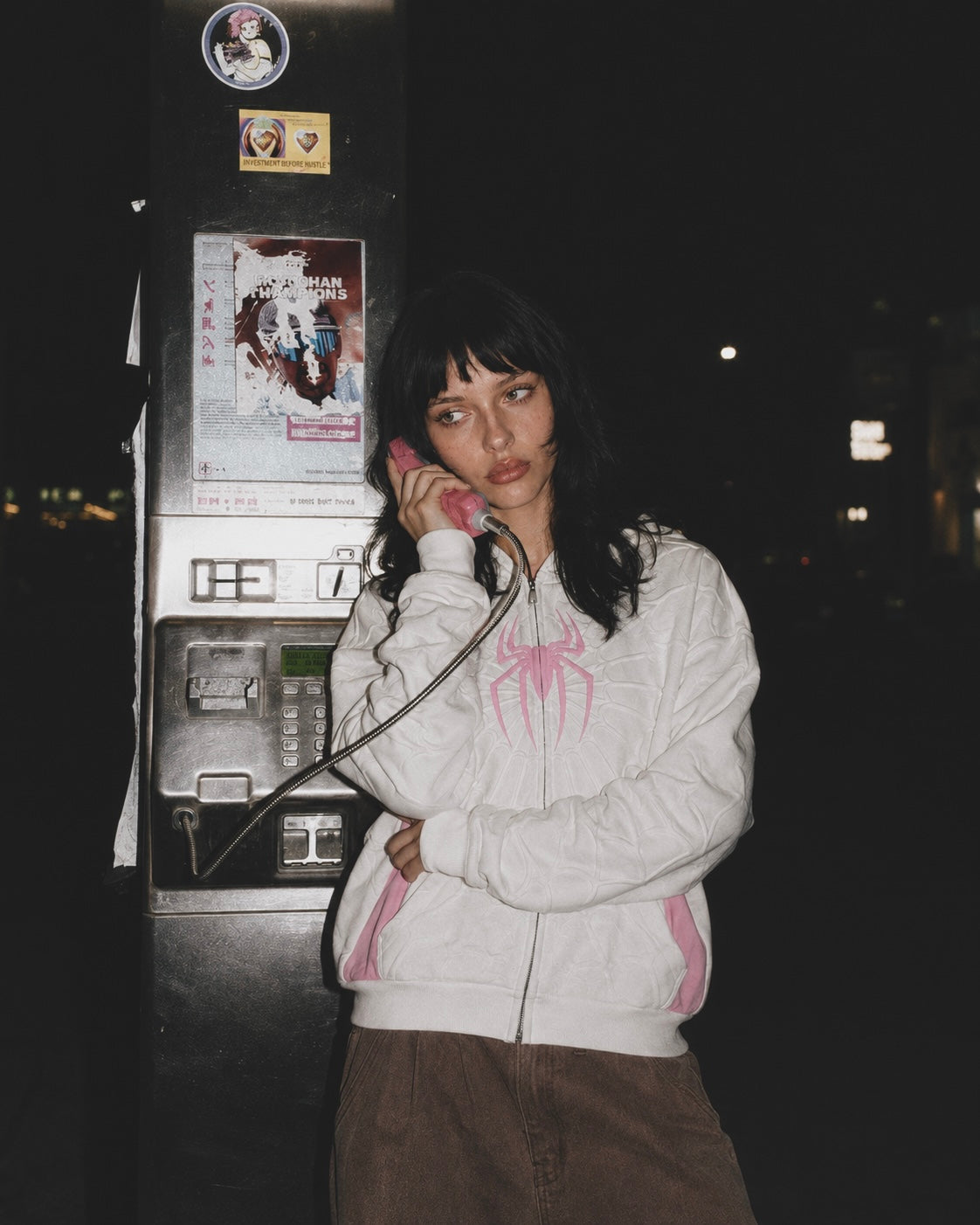 Nostalgic Misfits Ghost Zip white pink spidey hoodie female model night street shot using pink payphone brown cargo pants y2k nostalgia editorial