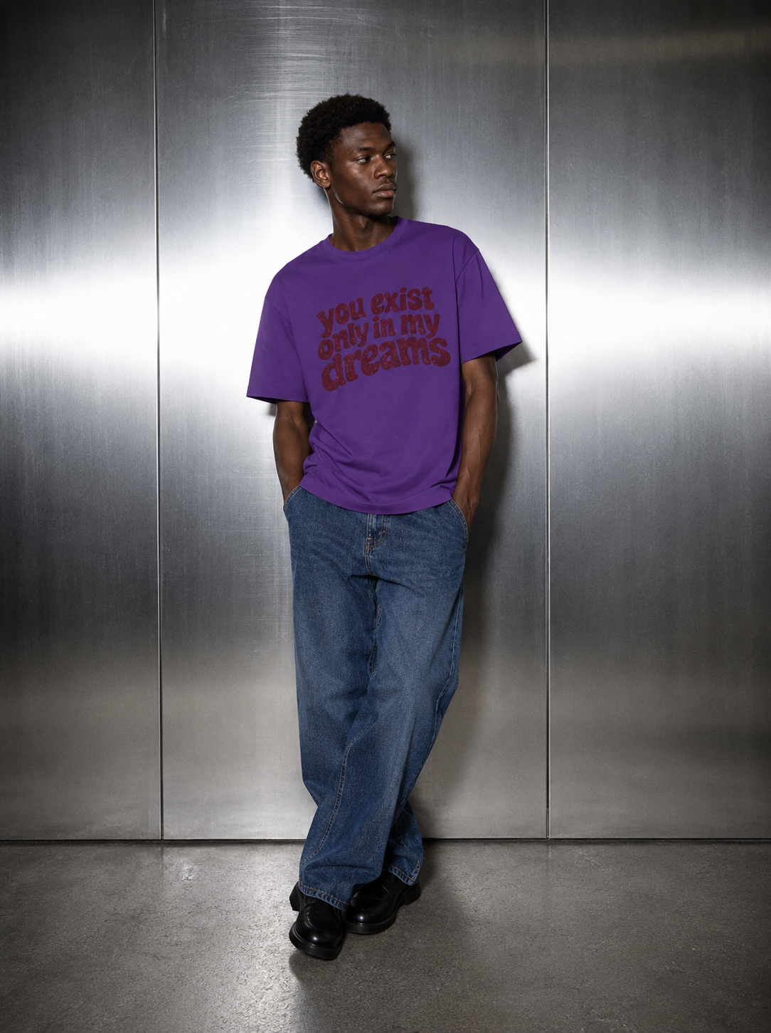 You Exist Only In My Dreams Tee purple worn by male model — 
oversized fit, styled with baggy blue denim jeans and 
black loafers, Nostalgic Misfits streetwear limited drop