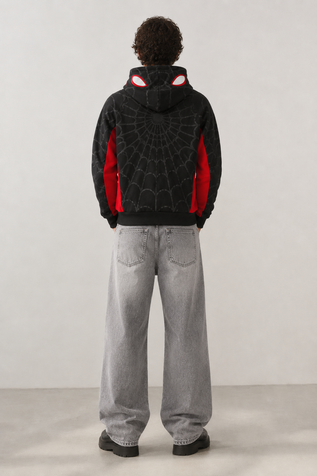 Nostalgic Misfits Miles Zip black red spidey hoodie back view model wearing baggy grey jeans showing web pattern red side panels and glowing spidey eyes on hood