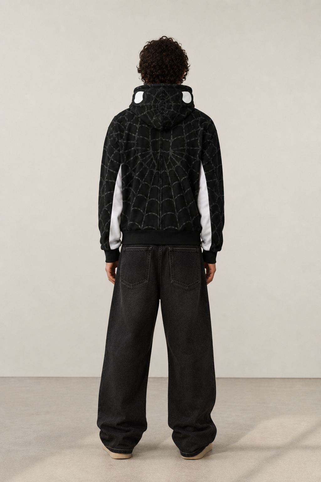 Nostalgic Misfits Noir Zip black white spidey hoodie back view male model baggy black jeans showing web pattern white side panels and spidey eyes on hood studio shot