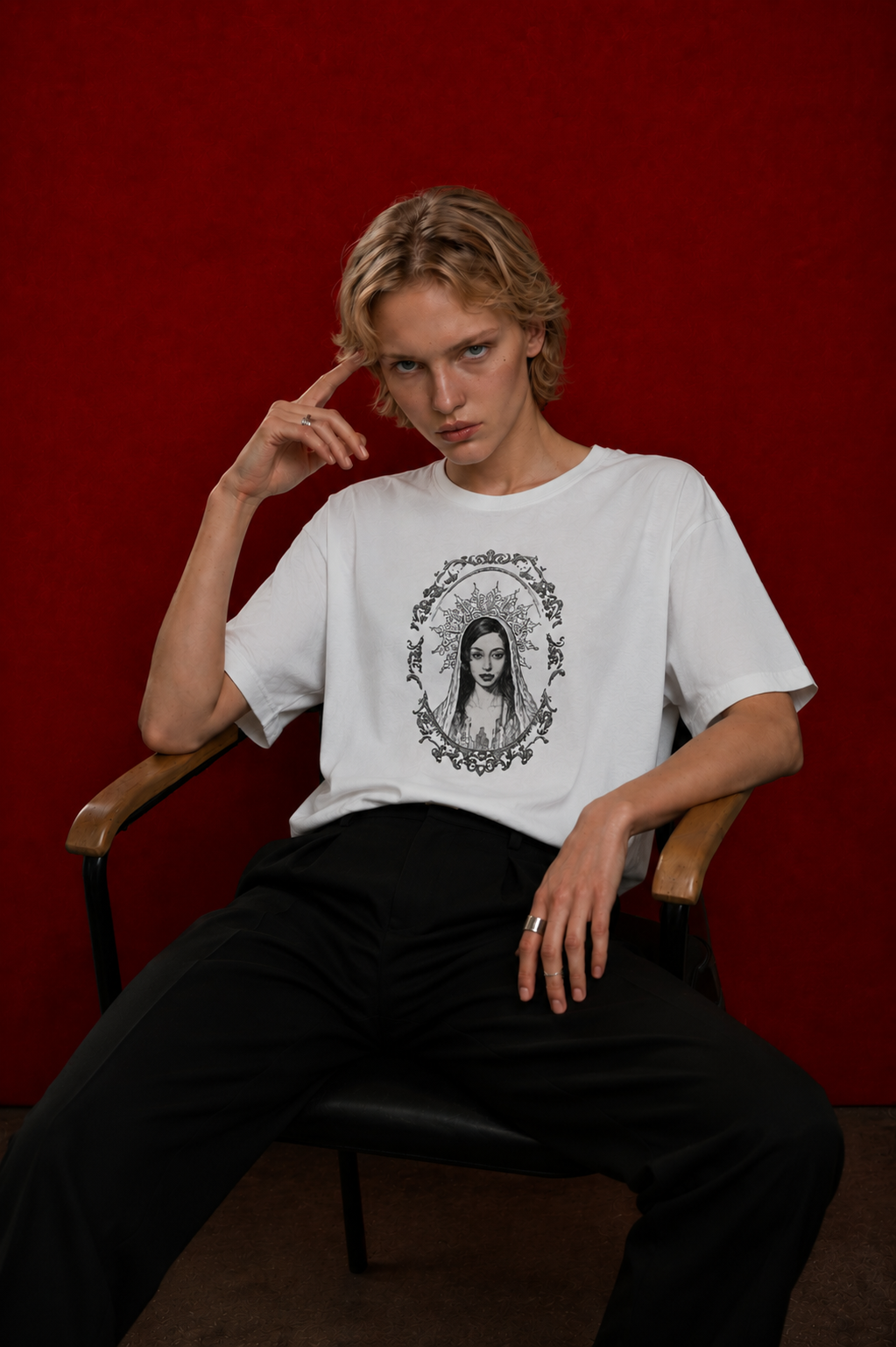 Model wearing Saint Maddy tee, baroque portrait print, seated against deep red background — Nostalgic Misfits EUPHORIC collection