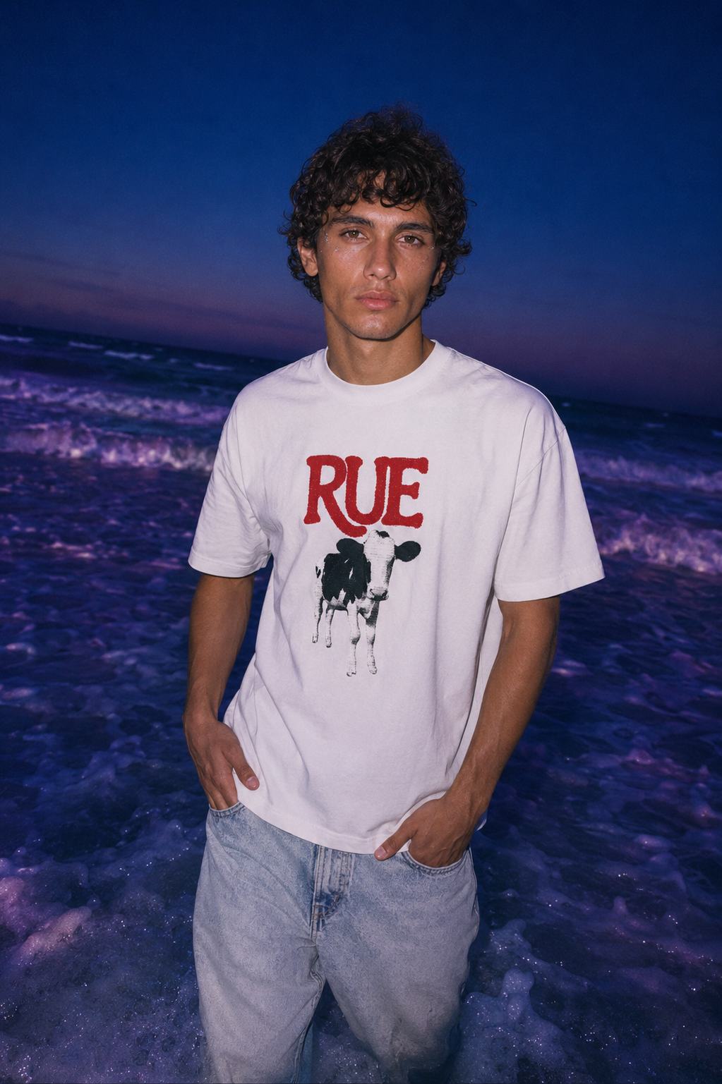 Model in white RUE oversized tee in night ocean, blue hour light - EUPHORIC collection by Nostalgic Misfits